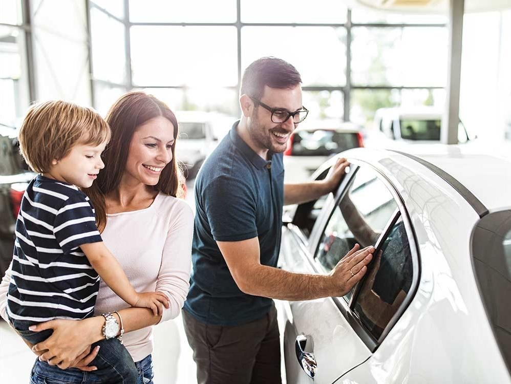 a family looking at cars at a car dealership
